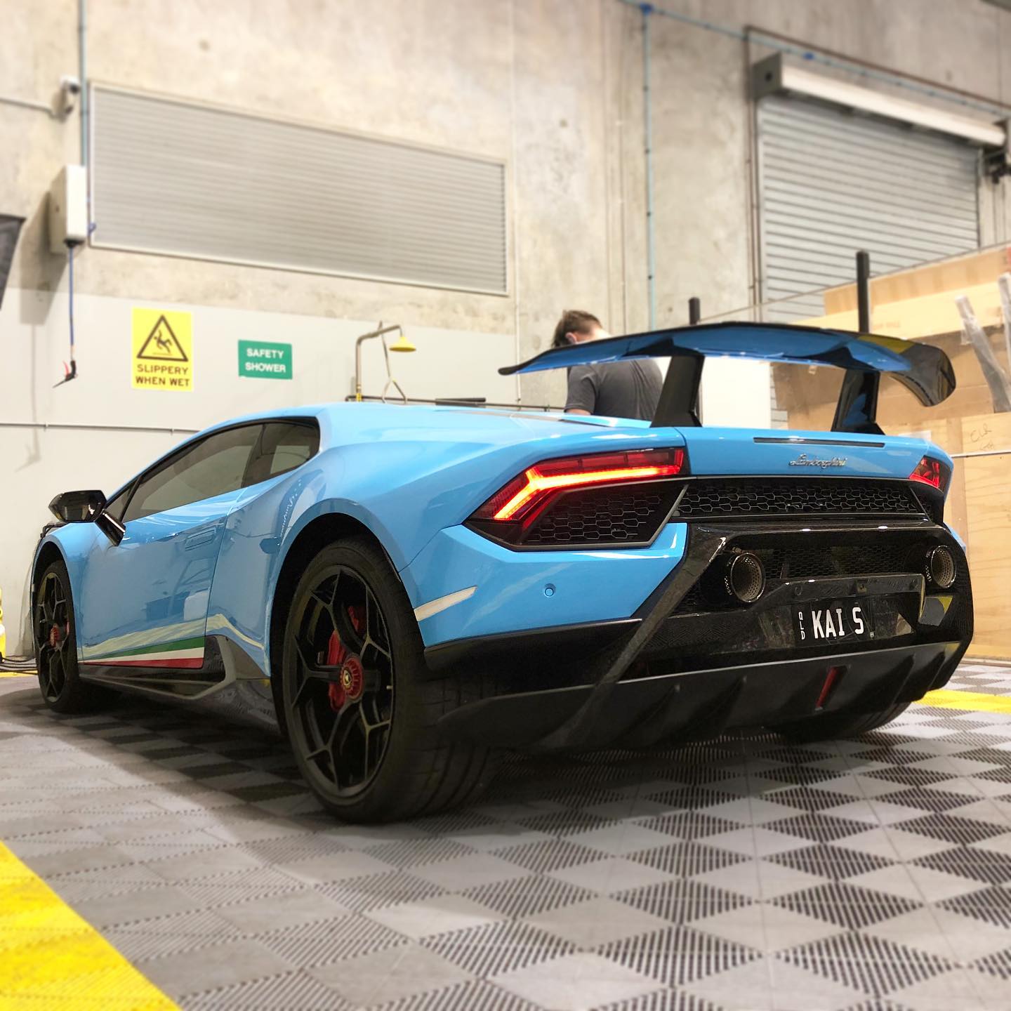 Glossy black exotic sports car inside The Car Spa Brisbane studio
